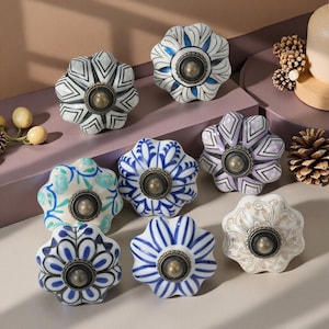 May include: A trio of ceramic mugs with a speckled, matte finish in cream, light grey, and dark grey. Each mug features a minimalist design and a rounded handle.