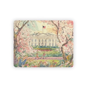 May include: A rectangular jigsaw puzzle featuring a watercolor illustration of the White House. The image shows the building framed by blooming cherry blossom trees, with people walking on a path in front of a green fence.