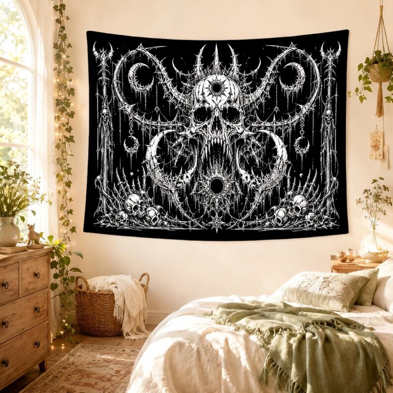 Pu&ograve; includere: Un arazzo da parete rettangolare caratterizzato da un'illustrazione grafica in bianco e nero ad alto contrasto. Il design mostra un teschio centrale con corna circondato da intricati motivi a ragnatela, lune crescenti e teschi alla base.