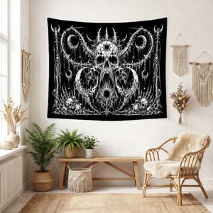 Pu&ograve; includere: Un arazzo da parete rettangolare con un'illustrazione grafica in bianco e nero ad alto contrasto. Il design raffigura un teschio centrale con corna circondato da intricati motivi a forma di spina, lune crescenti e teschi pi&ugrave; piccoli.