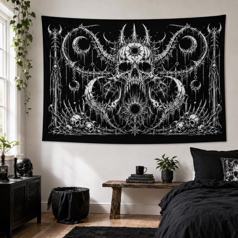Pu&ograve; includere: Un arazzo da parete in bianco e nero raffigurante un teschio centrale con denti affilati, circondato da intricati motivi a forma di spina, lune crescenti e teschi pi&ugrave; piccoli alla base. Il design &egrave; simmetrico con linee dettagliate su sfondo scuro.