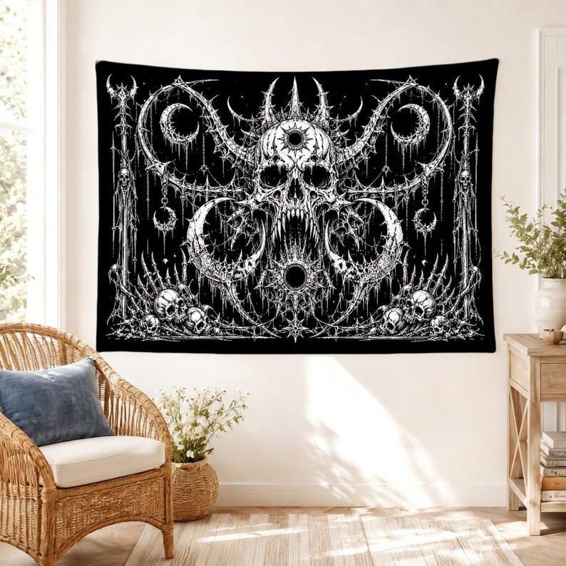 Pu&ograve; includere: Un arazzo da parete rettangolare con un'illustrazione in bianco e nero ad alto contrasto di un teschio centrale con corna circondato da intricati motivi gotici, lune crescenti e teschi pi&ugrave; piccoli disposti in una composizione simmetrica.