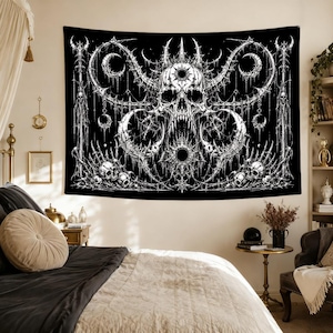Pu&ograve; includere: Un arazzo da parete rettangolare con un'illustrazione in bianco e nero ad alto contrasto di un teschio centrale cornuto con denti affilati, circondato da intricati filigrani gotici, lune crescenti e teschi pi&ugrave; piccoli alla base.
