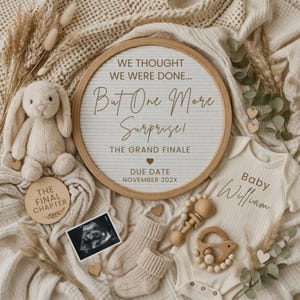 May include: A round felt letter board with the text WE THOUGHT WE WERE DONE... But One More Surprise! THE GRAND FINALE DUE DATE NOVEMBER 202X, a plush bunny, a baby onesie labeled Baby William, baby socks, a wooden rattle, and an ultrasound photo.