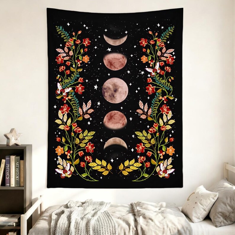 May include: A rectangular wall tapestry featuring a black background with a vertical sequence of five moon phases in the center. Two symmetrical floral vines with red flowers, green leaves, and white moths frame the lunar cycle on both sides.