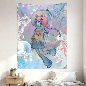 Op de afbeelding: Een groot wandtapijt met een grillige illustratie van een figuur in een ruimtehelm met een roze konijnenoren-ontwerp. De figuur draagt een geel shirt, een blauwe rok en blauwe laarzen, tegen een pastelkleurige achtergrond met sterren en krullen.