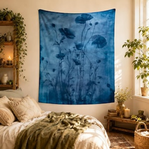 May include: A rectangular wall tapestry featuring a monochromatic deep blue botanical print of poppies and wildflowers. The design displays various floral silhouettes and stems against a textured, cloudy blue background, creating a layered effect.