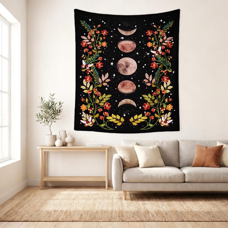 May include: A rectangular wall tapestry featuring a black background with a vertical sequence of five moon phases in the center. The design is framed by two symmetrical climbing floral vines with red, orange, and yellow flowers and green leaves.