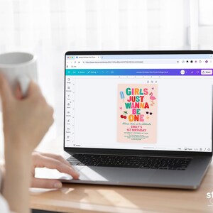May include: A laptop displays a birthday invitation design with the text "Girls Just Wanna Be One." The invitation features colorful graphics of ice cream, cherries, sunglasses, and a flamingo. The design is on a pink background.