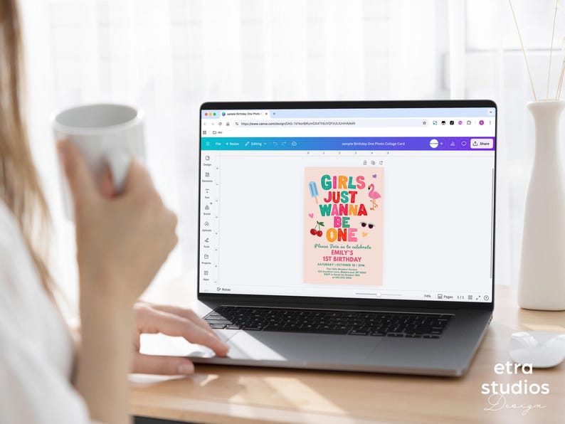 May include: A laptop displays a birthday invitation design with the text "Girls Just Wanna Be One." The invitation features colorful graphics of ice cream, cherries, sunglasses, and a flamingo. The design is on a pink background.
