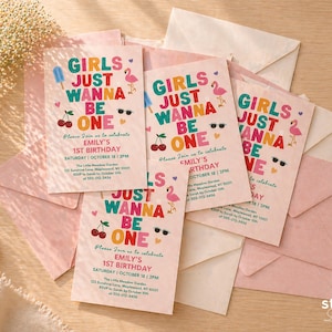 May include: Pink birthday invitations with the text "GIRLS JUST WANNA BE ONE" in colorful letters. The invitations feature illustrations of a popsicle, sunglasses, cherries, and a flamingo. The invitations are surrounded by pink and cream envelopes.