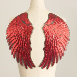 May include: A pair of red sequined angel wings, perfect for adding a touch of sparkle to any costume or craft project.
