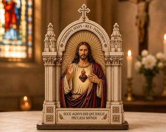 May include: A decorative religious figurine featuring a central figure of Jesus with a Sacred Heart, housed within an architectural archway structure. The base displays the text ECCE AGNVS DEI QVI TOLLIT PECCATA MVNDI and DOMINVS IESVS REX IVDAEORVM.