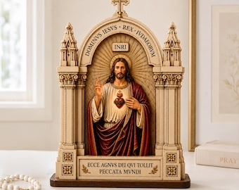 May include: A cream-colored resin sculpture of the Sacred Heart of Jesus set within a gothic-style archway. The figure wears a white robe and red mantle, with the text DOMINVS IESVS REX IVDAEORVM, INRI, and ECCE AGNVS DEI QVI TOLLIT PECCATA MVNDI.
