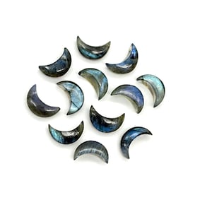 Könnte beinhalten: Eine Sammlung halbmondförmiger Edelsteine. Die Steine haben eine Mischung aus blauen, grauen und irisierenden Farben. Die Edelsteine sind auf einer weißen Oberfläche angeordnet. Ideal für die Schmuckherstellung oder das Basteln.