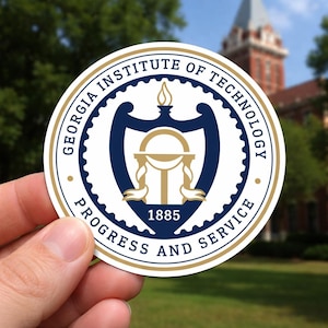 May include: A round sticker featuring the Georgia Institute of Technology seal. The seal is white, navy blue, and gold, with the text "Georgia Institute of Technology" and "Progress and Service". The year "1885" is also displayed.