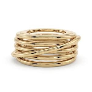 Puede incluir: Un anillo de oro pulido con un diseño en espiral de varias capas compuesto por varios aros lisos e interconectados que se envuelven para formar una sola pieza continua. El texto GoldenDiamond está impreso en pequeñas letras negras en la base.