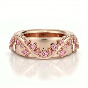 May include: A rose gold band ring featuring a series of small, round, pink gemstones set along a curved, vine-like metal overlay that wraps around the centre of the band. The ring has a polished finish and a symmetrical design with multiple pink stones.