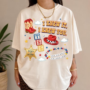 A person wearing a white t-shirt with various cartoon-style icons and text printed on it.