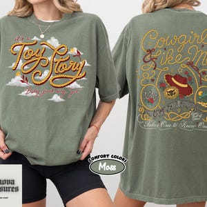 a woman wearing a green t-shirt with a graphic design on the front and back.