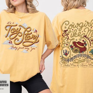 a woman wearing a yellow t-shirt with a design on the front and back.