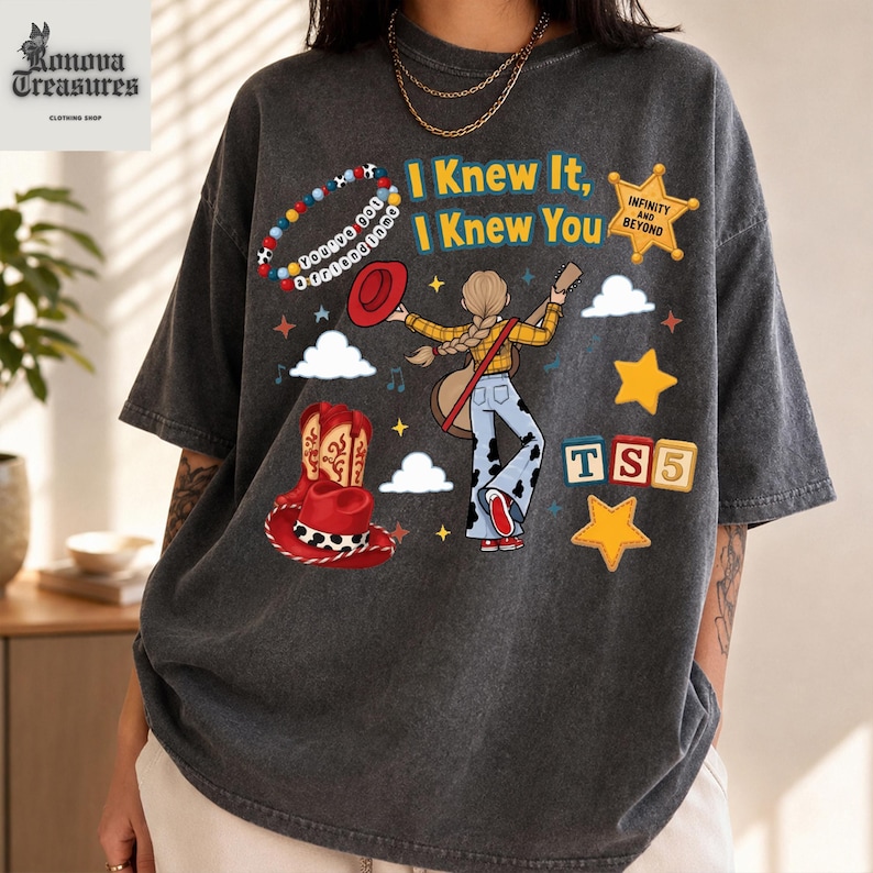 A person wearing a gray t-shirt with a graphic design featuring a cowboy hat, a star, and various other elements.