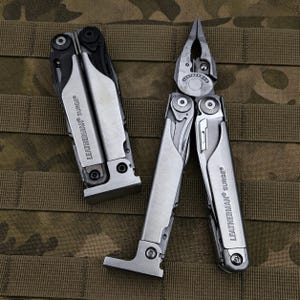 Puede incluir: Una herramienta multifunción Leatherman Surge plateada y negra mostrada en posición plegada y abierta. La herramienta cuenta con alicates integrados, mangos de metal con el logotipo Leatherman Surge y tornillos visibles en la estructura.