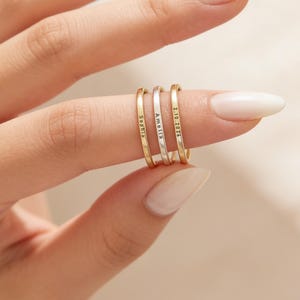 Peut inclure: Ensemble de trois mugs en céramique avec une finition mate et mouchetée. Les mugs sont de couleur crème, gris clair et gris foncé. Chaque mug présente un design simple et minimaliste.