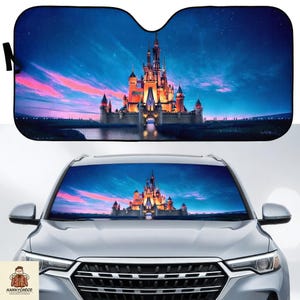 May include: A car windshield sunshade featuring a vibrant image of a fairytale castle at dusk. The castle is illuminated against a backdrop of a blue and pink sky. The sunshade is black and designed to fit a car windshield.