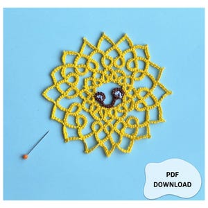 Può includere: Un disegno di sole all'uncinetto giallo con un volto sorridente, su sfondo azzurro. Una puntina con la testa arancione è posta vicino al sole. Il testo "PDF DOWNLOAD" è in un fumetto bianco.