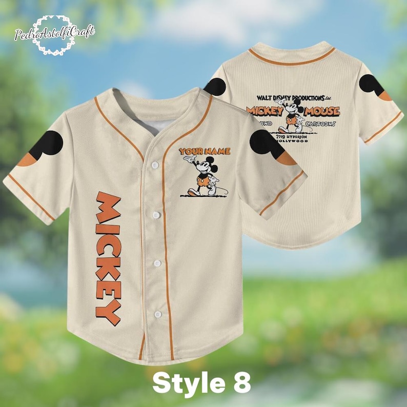 A beige baseball jersey with Mickey Mouse printed on it, featuring a personalized name tag and a Mickey Mouse logo.