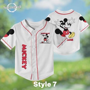 A white baseball jersey with a Mickey Mouse design on the front and back, featuring the word "MICKEY" in red letters.