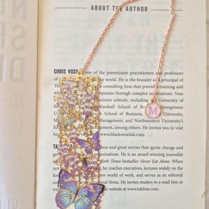 Set of four custom-initial gold-tone metal bookmarks with butterfly and floral filigree, personalized, in blue packaging.
