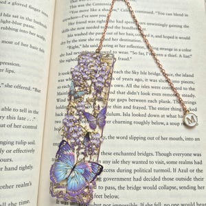 Set of four custom-initial gold-tone metal bookmarks with butterfly and floral filigree, personalized, in blue packaging.
