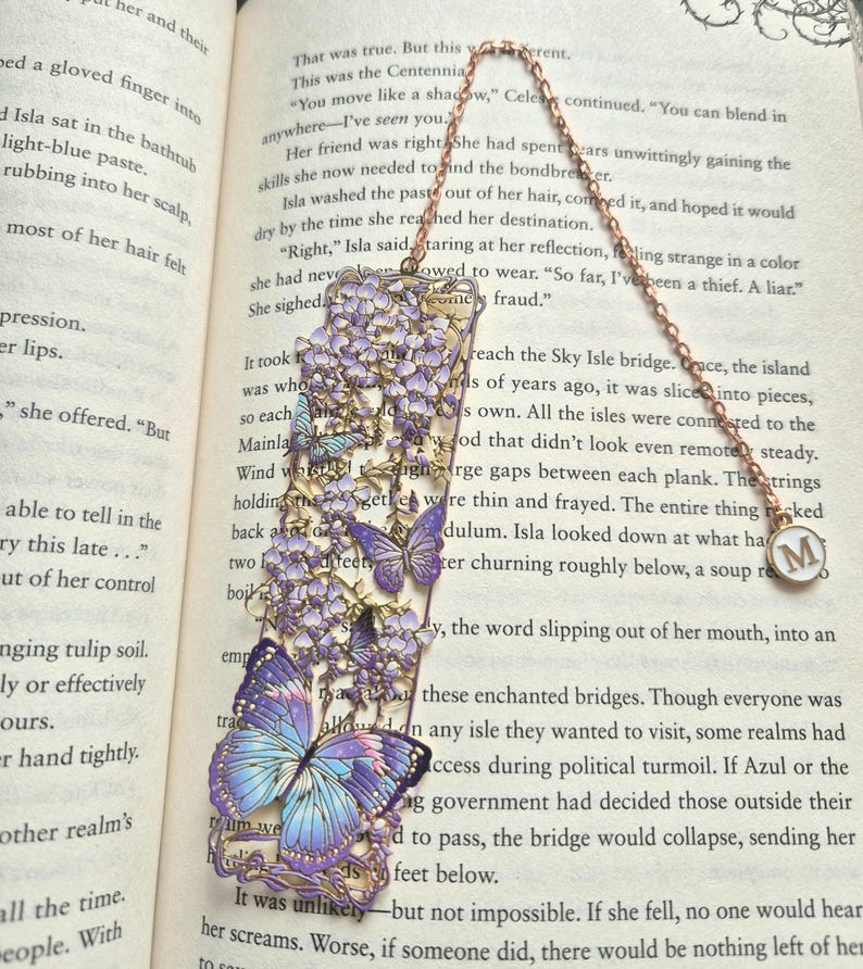 Set of four custom-initial gold-tone metal bookmarks with butterfly and floral filigree, personalized, in blue packaging.