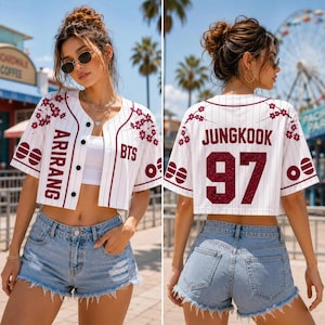 Op de afbeelding: Een wit kort honkbalshirt met dunne verticale krijtstrepen, bordeauxrode biezen en bordeauxrode tekst ARIRANG en BTS op de voorzijde. De achterkant toont JUNGKOOK en het nummer 97 in bordeauxrood, met kersenbloesemafbeeldingen op de schouders.