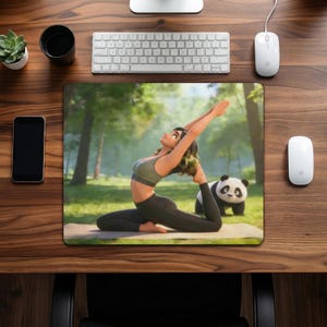 May include: A yoga mouse mat featuring a woman in a yoga pose with a panda bear in a forest setting. The woman is wearing a green sports bra and black leggings. The mouse mat is on a wooden desk with a keyboard, mouse, phone, and a small plant.