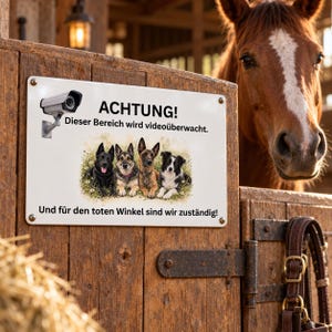 May include: A rectangular white metal sign featuring a black security camera icon, the text ACHTUNG! Dieser Bereich wird videoüberwacht., an illustration of four dogs sitting in grass, and the text Und für den toten Winkel sind wir zuständig!.