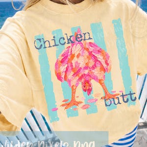 May include: Yellow t-shirt with a colorful illustration of a chicken's rear end, with the words "Chicken butt" in blue text. The shirt has a relaxed fit and short sleeves.