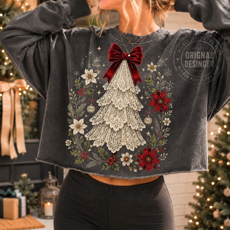 Pu&ograve; includere: Una felpa corta grigio antracite con la grafica di un albero di Natale in pizzo sormontato da un grande fiocco di velluto rosso. Il disegno &egrave; circondato da una ghirlanda di stelle di Natale, agrifoglio e decorazioni. Testo: WILDER PIXELS PNG SHOP.