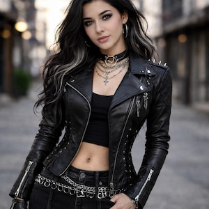 May include: A black leather jacket with silver zips, studs, and lace-up detailing. The jacket is worn with black jeans and a silver chain belt. A black choker and layered necklaces complete the look. The style is a modern take on a classic biker aesthetic.
