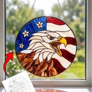 Può includere: Un acchiappasole rotondo in vetro colorato con un disegno di aquila e la bandiera americana. L'acchiappasole è diviso in sezioni di blu con stelle, strisce rosse e bianche e la testa dell'aquila. Il testo in alto recita "EAGLE SUN CATCHER Instant Download PDF".
