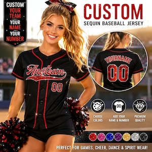 May include: A black baseball jersey with red sequin trim, featuring the text Anyteam and the number 00 on the front, and the text YOURNAME with the number 00 on the back. The jersey includes a matching red and black sequin hair bow accessory.