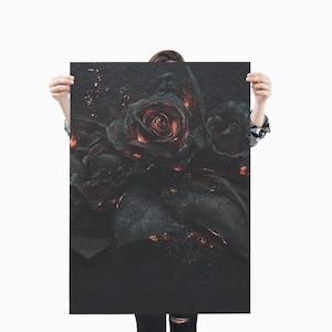 May include: A dark, textured art print featuring a bouquet of roses. The roses are primarily black with hints of red and orange, creating a dramatic contrast. The artwork is held up against a white background.