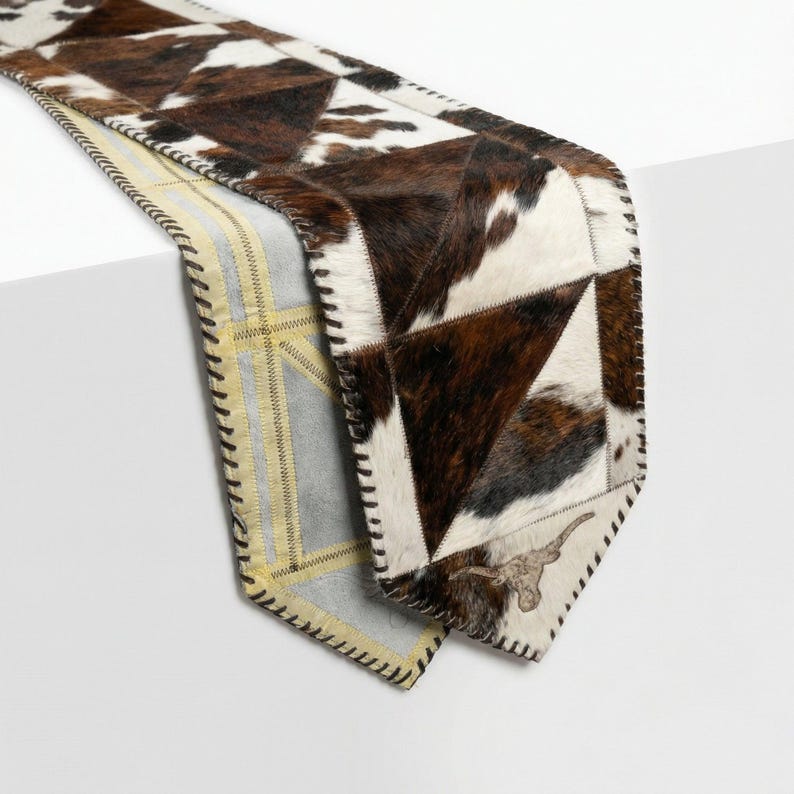 Handmade cowhide table runner with tricolor patchwork leather, longhorn ends, hair on hide panels, western rustic decor, farmhouse dining table accent, leather lace edges, natural cowhide texture
