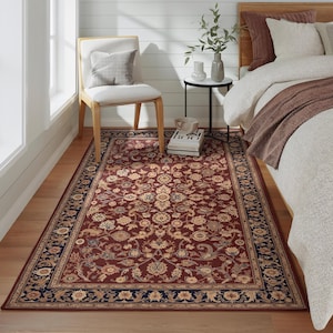 May include: A rectangular area rug with a deep red background and an intricate floral pattern in beige and gold. The rug has a dark blue border with floral motifs, adding a classic touch to the room's decor.
