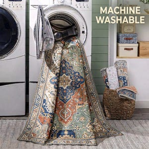 a large rug with a colorful, intricate design hanging from an open washing machine in a laundry room.