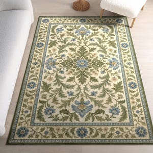 May include: A rectangular area rug featuring a cream-coloured background with a symmetrical botanical pattern. The design includes intricate green acanthus leaves and blue floral motifs arranged in a central medallion with a matching border.