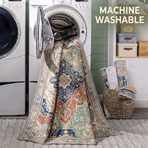 a large rug with a colorful, intricate design hanging from an open washing machine in a laundry room.