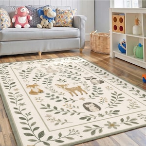 a cozy living room with a gray couch, a rug featuring a forest scene, and various stuffed animals and decorative items.